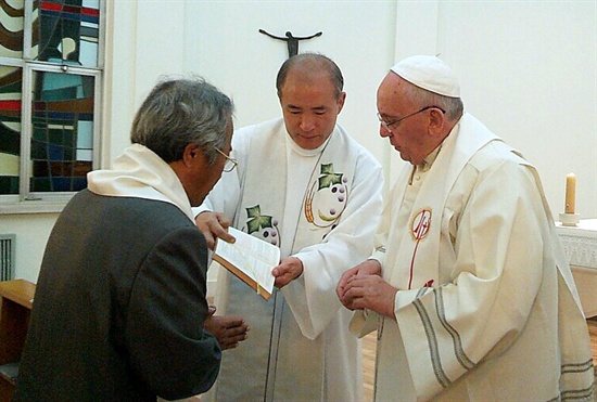 세월호참사 희생자인 단원고 이승현군의 아버지 이호진씨가 지난 17일 오전 주한 교황대사관에서 프란치스코 교황으로부터 세례를 받는 모습.