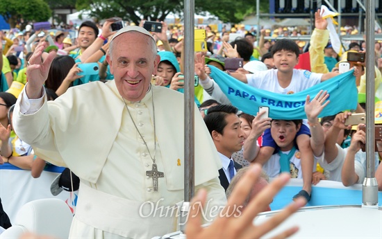 방한 4일째인 프란치스코 교황이 지난 17일 충남 서산시 해미읍성에서 열리는 아시아 청년대회 폐막미사를 집전하기위해 입장하며 신자들과 시민들에게 손을 들어 인사하고 있다.