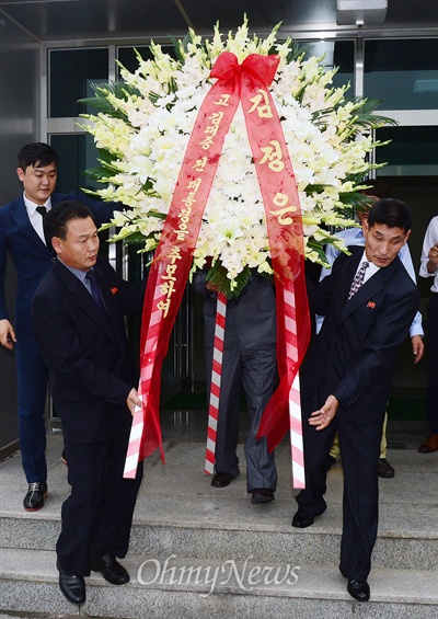 고 김대중 전 대통령 5주기, 김정은 위원장 조화 고 김대중 전 대통령 5주기를 하루 앞둔 17일 개성공단 종합지원센터 옆 북측 개성공단 총국사무소에서 김정은 국방위원회 제1위원장 명의의 조화가 우리측이 준비한 차량으로 옮겨지고 있다.