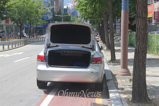 창원시내 한 도로 위에 주차해 놓은 차량인데, 자전거도로 위에 주차를 해놓았고, 번호판이 보이지 않도록 트렁크를 열어 놓았다.