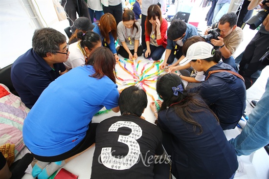 세월호 유가족들이 21일 오후 서울 광화문 세월호농성장에서 2달간 접은 종이학을 선물한 동경국제대학교 학생들과 종이학의 날개를 펼치고 있다.