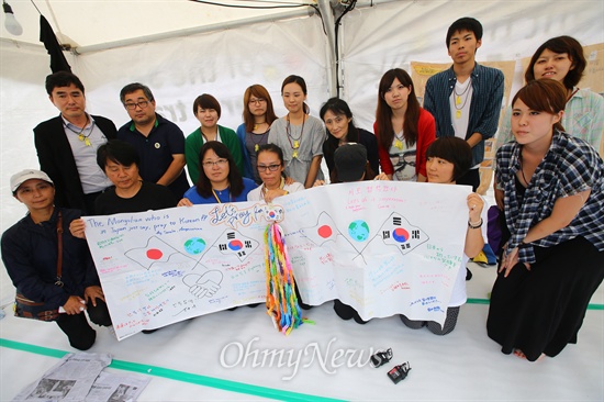  세월호 유가족들이 21일 오후 서울 광화문 세월호농성장에서 2달간 접은 종이학과 편지를 선물한 동경국제대학교 학생들과 함께 사진을 찍고 있다.