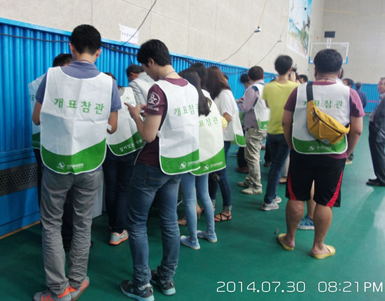 7.30 재보선 개표 때 투표함을 확인하는 개표참관인. 정규투표함 바꿔치기 확인 위한 NFC칩 조회하는 모습은 없었다.