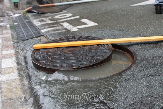 25일 오후 내린 폭우로 1.5m 가량까지 물이 차올랐던 부산 연산동에서 하수구 맨홀 속 빗물이 역류하고 있다. 
