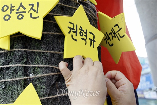  세월호 공판 때마다 참사 유가족을 맞이하기 위해 '진실마중 사람띠잇기'를 해 온 '세월호 3년상을 치르는 광주시민상주모임'이 26일 오후 9시 30분 유가족이 지나는 도로의 가로수에 위로의 메시지를 매다는 '세월호 진실나무 퍼포먼스'를 벌였다. 세월호 참사 실종자·희생자를 상징하는 노란 별이 나무에 걸리고 있다.