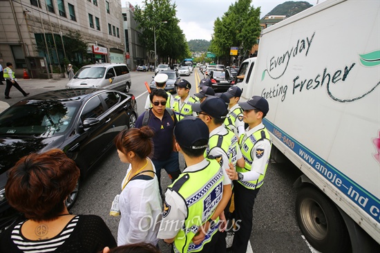 농성 중인 세월호 유가족을 방문하려는 한 시민이 26일 오후 서울 종로구 청운효자동 주민센터 앞 횡단보도를 건너던 중 도로 한가운데서 경찰에게 둘러싸여 있다.