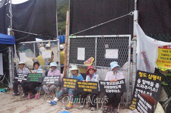경북 청도군 각북면 삼평리 송전탑 건설을 반대하는 주민들이 공사장 입구에서 피켓을 들고 앉아 있다.
