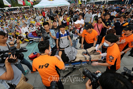 집회 도중 한 참석자가 쓰러져 들것에 실려 구급차로 옮겨지고 있다.