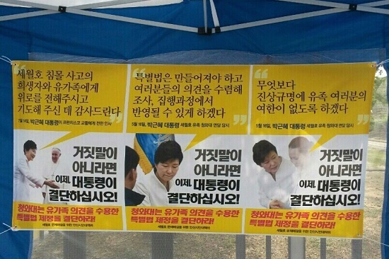 서울 광화문 단식 농성장 텐트에 박근혜 대통령이 유가족과 세월호 특별법과 관련해 발언한 말에 대해 책임을 질 것을 요구하며 결단을 촉구하는 펼침막이 게시되어 있다. 