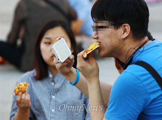 일베 회원등이 세월호 진상규명 특별법 단식농성장 앞에서 '도시락 나들이' 등 먹거리 집회를 예고한 지난 6일 오후 서울 광화문광장 세종대왕상 앞에서 한 남성이 피자를 먹고 있다.