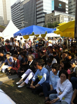 세월호 차례상 앞에서 2학년4반 최성호 아빠의 편지를 듣고 있는 시민들