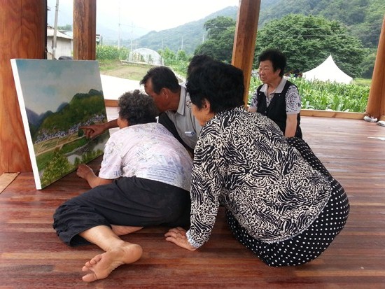 그림을 보며 '우리집은 어디에 있데아' 마을 사람들 가르키고 있다.

그림 정종임