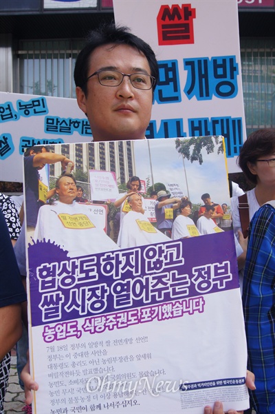 쌀 전면개방 반대를 요구하는 경북지역 농민들의 기자회견이 11일 오전 새누리당 대구시당 앞에서 열린 가운데 한 참가자가 쌀 시장 개방을 선언한 정부를 비판하는 피켓을 들고 있다.