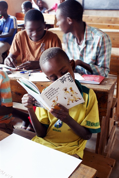 바투에서 만든 동화책을 열심히 보고 있는 부룬디의 한 아이