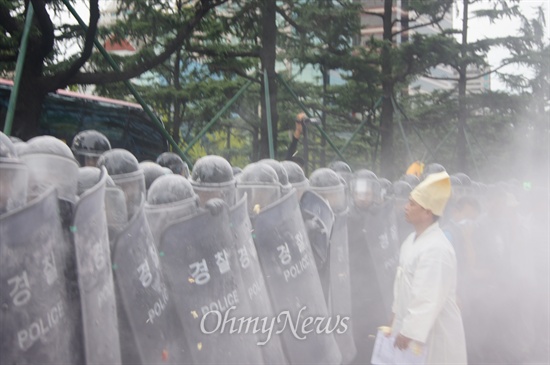 18일 오후 새누리당 경북도당 앞에서 열린 경북농민대회에서 농민들이 불태운 상여를 경찰들이 소화기를 이용해 강제로 진압하자 상복을 입은 한 농민이 경찰에게 항의하고 있다. 