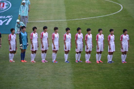  경기 시작 전 국기를 향해 서서 국가를 부르고 있는 북한 여자축구 선수들