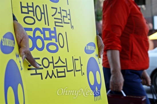 2011년 1월 13일 광주 동구 삼성생명 건물 앞에서 1인시위를 시작한 '삼성의 사회적책임을 요구하는 시민모임(삼사모)'이 3년 8개월 동안 했던 1인시위를 25일 마무리했다. 삼사모 회원들이 든 피켓 너머로 한 시민이 지나가고 있다.