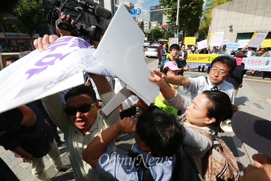 보수단체 회원들이 맞은편 기자회견장으로 몰려오며 피켓을 부수는 등 몸싸움을 벌이고 있다.
