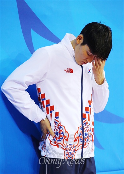  은메달을 차지한 박태환 선수가 25일 오후 인천 문학박태환수영장에서 열린 남자 자유형 100미터 결승전 경기가 끝난 직후 시상식에서 얼굴을 만지며 수상을 기다리고 있다.
