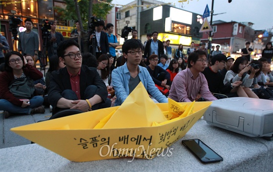 성균관대 불허, 야외에서 열린 세월호 유가족 간담회 26일 오후 서울 종로구 성균관대학교 정문 앞에서 열린 세월호 유가족과 학생과의 간담회에 참석한 세월호 유가족 유경근 대변인의 이야기를 경청하고 있다.
세월호 유가족은 지난 22일부터 서울 시내 대학을 찾아 학생과의 간담회를 진행하고 있지만, 성균관대학교는 세월호 유가족과 학생과의 간담회를 정치적 활동이라며 강의실 사용을 불허해 이날 행사는 정문 앞에서 열렸다.