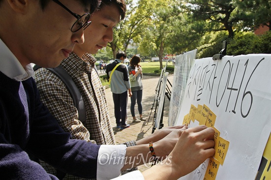 전남대 축제에 마련된 '공감 스페이스'에 2일 학생들이 세월호를 기억하는 마음을 담아 쪽지를 붙이고 있다.