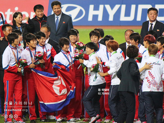  남과 북 여자축구 선수들이 함께 기념촬영하기 위해 움직이고 있다. 