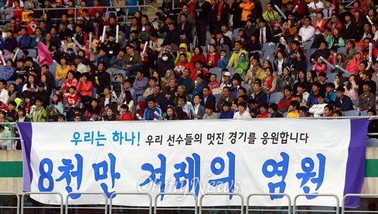 남북공동응원단 "우리는 하나다" 남북공동응원단이 2일 오후 인천 문학월드컵경기장에서 열린 '2014 인천아시아경기대회' 축구 남한과 북한과의 결승전에서 대형현수막을 펼쳐보이며 "우리는 하나다"를 외치고 있다.