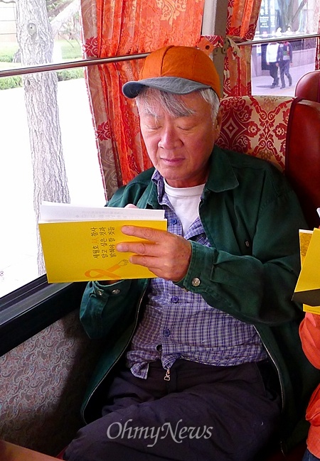 소설가 김훈씨가 3일 오전 전남 진도 팽목항으로 가는 버스에 앉아 메모를 하고 있다.
