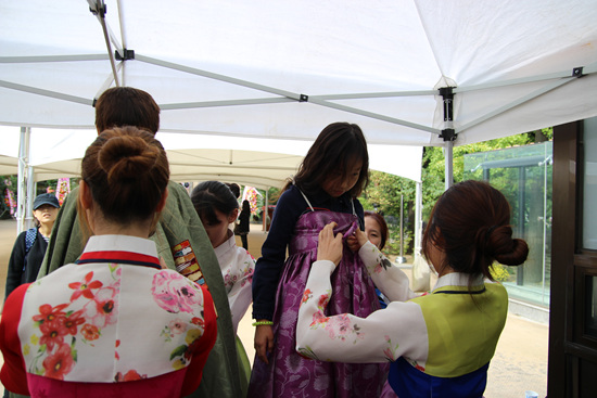 한복소녀단이 어린이들에게 한복을 입혀주고 있다.