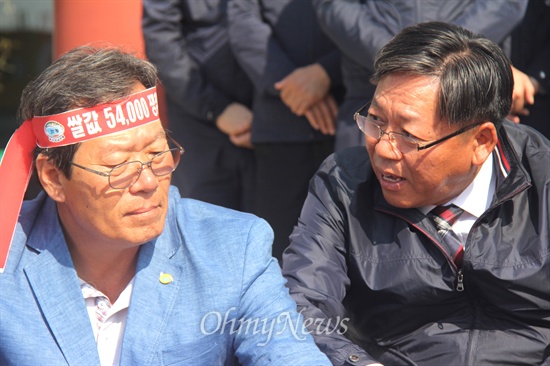  전국농민회총연맹 부산경남연맹 농민들이 "쌀값 폭락 외면하는 농협 규탄한다"며 7일 오후 농협중앙회 경남지역본부 앞에서 기자회견을 연 뒤 계단에 앉아 있는 가운데, 농협중앙회 경남본부 장승현 부본부장이 하원오 의장 옆으로 다가와 말을 건네고 있다.