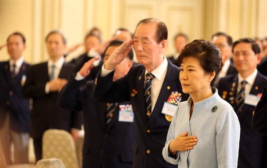 박근혜 대통령과 참석자들이 8일 청와대 영빈관에서 열린 재향군인의 날 기념 임원들과의 오찬에서 국기에 대한 경례를 하고 있다.