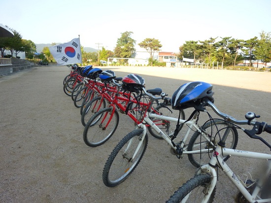 운동장에 나란히 서있는 자전거들