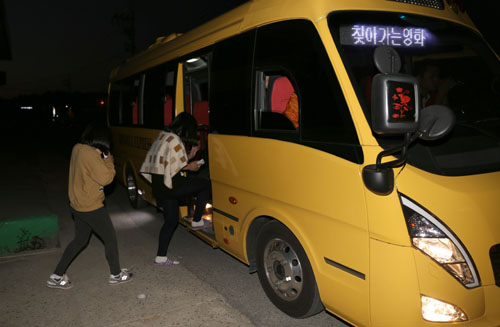비금중학교 학생들이 '찾아가는 영화관'이 들어선 비금초등학교로 가기 위해 마을 앞에서 시네마 버스에 오르고 있다.