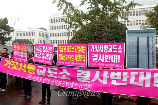 '학교 앞 교도소 반대 범거창군민대책위원회' 회원들이 20일 경남도교육청 앞에서 피켓과 펼침막을 들고 서 있다.