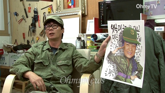작가 이하 씨가 자신이 만든 박근혜 대통령 풍자 포스터 하나를 들고 인터뷰에 응하고 있다.