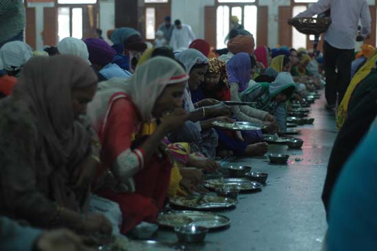 황금사원 식당에서는 부자와 가난한 사람 모두 한자리에서 무료로 제공되는 식사를 하고 있다.