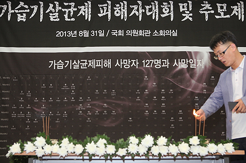 2013년 8월31일 국회 의원회관에서 열린 가습기살균제 피해자 추모제에서 백승목씨가 국화꽃을 헌화한 후 분향하고 있다.