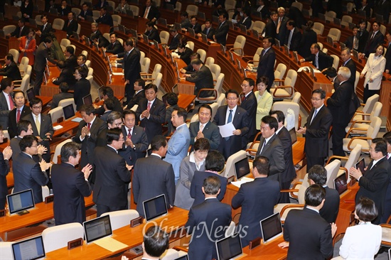 박근혜 대통령이 29일 오전 국회에서 열린 본회의에서 내년도 예산안에 대한 시정연설을 마친뒤 의원들과 인사하며 퇴장하고 있다. 새누리당 의원들이 기립박수를 친 반면, 새정치민주연합 등 야당 의원들은 자리에 그대로 앉아 있다. 