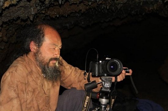 동굴을 촬영 중인 이시우작가. 2014년 4월 제주에서  동굴을 촬영했다.
그는 휴대가 간편한 작은 '똑딱이'카메라를 주로 사용하는데 이 날은 필자의 카메라를 함께 사용했다.