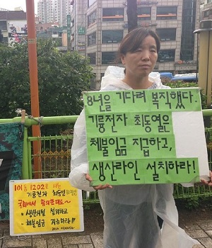 유흥희 분회장이 최동열 회장 집 앞에서 피켓을 들고 서 있다. 