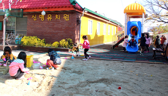 신명유치원의 현재 모습. 최근 단장을 마친 놀이터에서 아이들이 모래놀이를 하고 있다.
