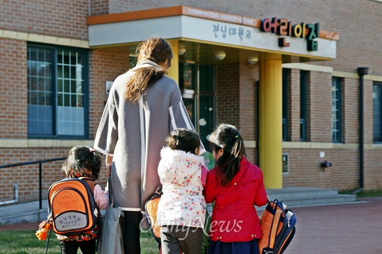 10일 오전, 한 학부모가 아이들의 손을 잡고 전남대 어린이집에 들어가고 있다.