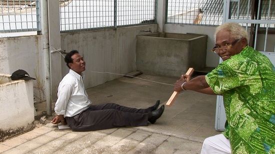  영화 <액트 오브 킬링>의 한 장면. 대학살의 주범 '안와르 콩고(사진 속 오른쪽)'는 천연덕스럽게 웃으며 당시 살해방법을 재연한다.