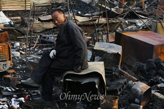 지난 11월 원인 미상의 화재가 발생해 잿더미로 변한 강남 구룡마을에서 한 주민이 자신이 사용하던 집기들을 찾다 지쳐 그 자리에 주저 앉았다.