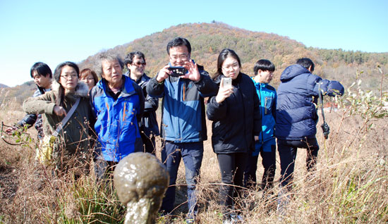 충남 공주시 쌍신공원 인근 버려진 나무 폐자재에 큰빗이끼벌레가 자라고 있다. 참석자들이 호기심 어린 눈으로 보고 있다.