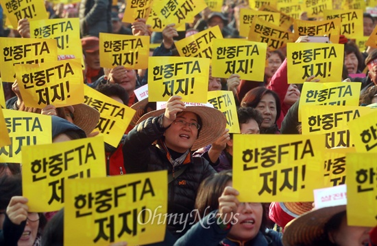 전국에서 상경한 농민과 시민들이 20일 오후 서울 중구 서울시청광장에서 열린 '한중FTA저지 쌀전면개방반대 식량주권과 먹거리안전을 위한 3차 범국민대회'에 참석해 한·중FTA 피켓을 들어보이며 구호를 외치고 있다.