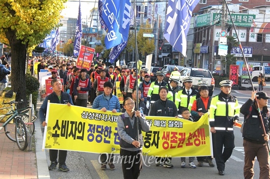  올해 7살인 안병석군이 아버지와 함께 지난 23일 오후 진주에서 열린 "삼성전자서비스 진주센터 폐업철회 결의대회"에 참석해 거리행진하며 구호를 외치고 있다.