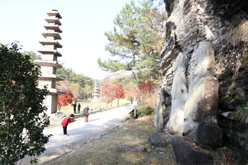  운주사 석불과 석탑. 이웃집 아저씨처럼 편안한 자세로 바위 벽에 기대고 서 있다.