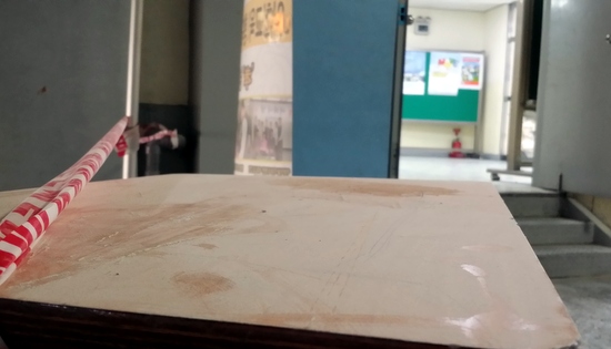 지난 24일 오전 서울 A중학교 공사장에서 복도 건너편 학생 교실을 바라보며 찍은 사진. 성분불명의 분진이 책상 위에 쌓여 있다. 
