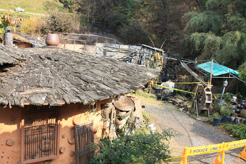 황토집과 나무지붕으로 덮여있는 뒷편으로 전소된 화재현장